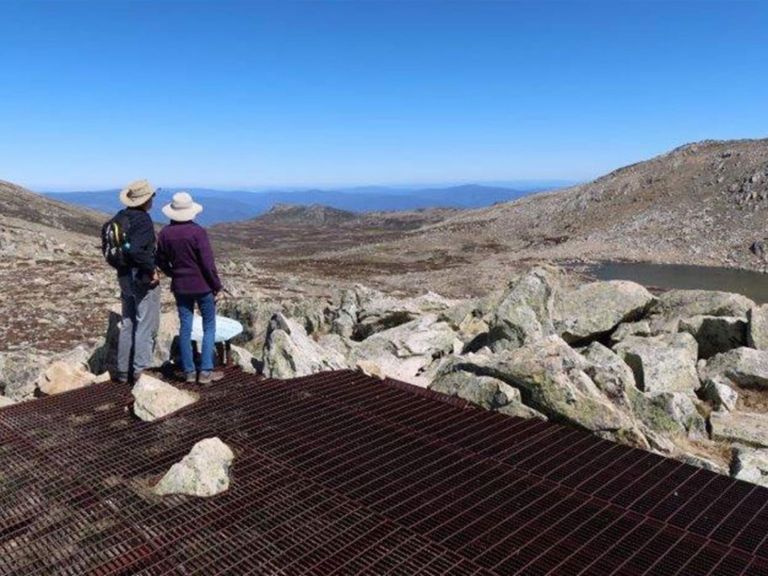 A couple takes in the view from Cootapatamba lookout in Kosciuszko National Park. Photo: Luke