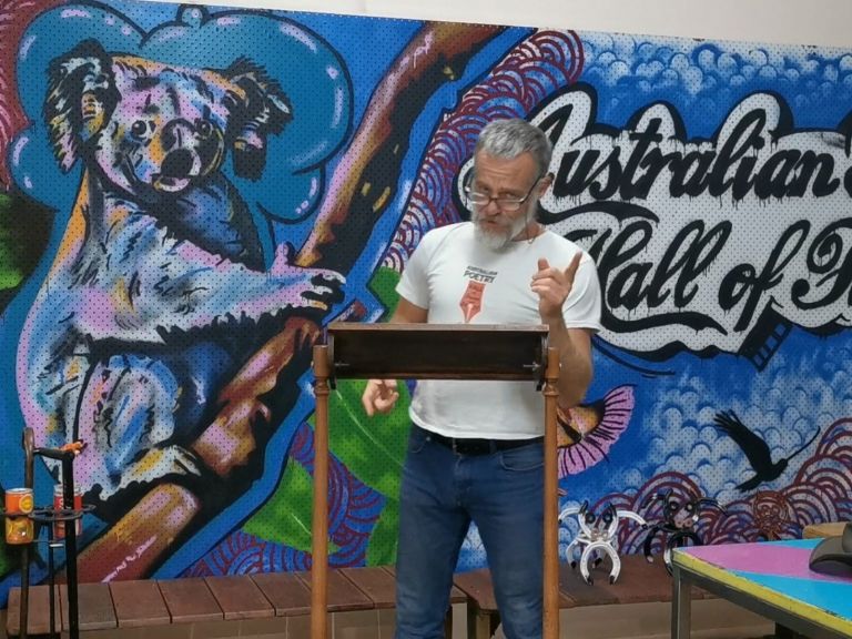 Thundercloud reciting poetry in front of Australian Poetry Hall of Fame mural