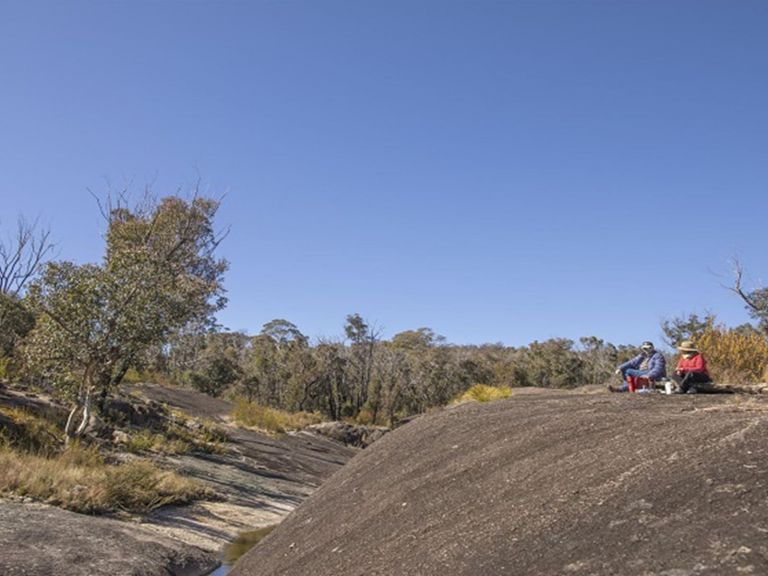 Visitors sitting on the granite rock formations at Morgans Gully picnic area. Photo: Joshua J  Smith