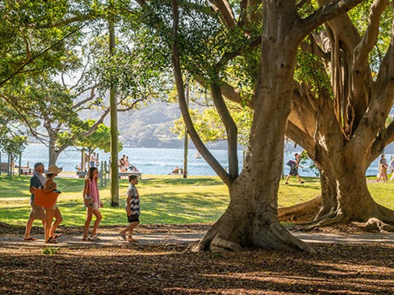 Family walking beneath the trees at Nielsen Park. Photo: John Spencer/DPIE