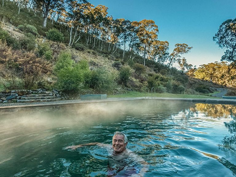 A man relaxes in the steaming waters of Yarrangobilly Caves thermal pool, in Kosciuszko National