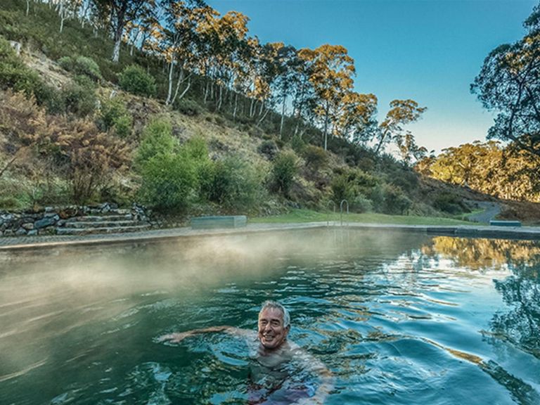 A man relaxes in the steaming waters of Yarrangobilly Caves thermal pool, in Kosciuszko National