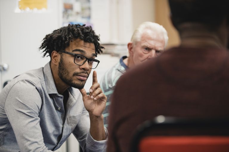 Image of man listening to a group discussion 