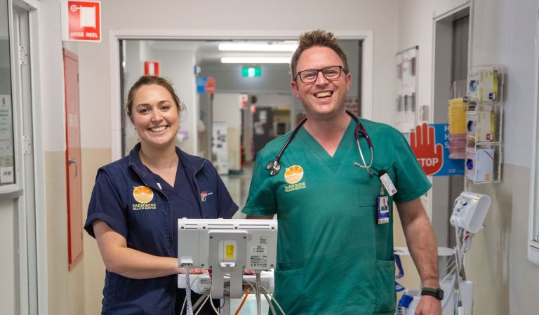 Nurse and doctor standing in hallway at Narromine smiling