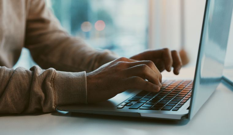 An unrecognisable businessman working on his laptop in the office