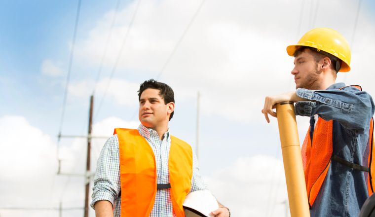 Two male powerline workers wearing high-vis