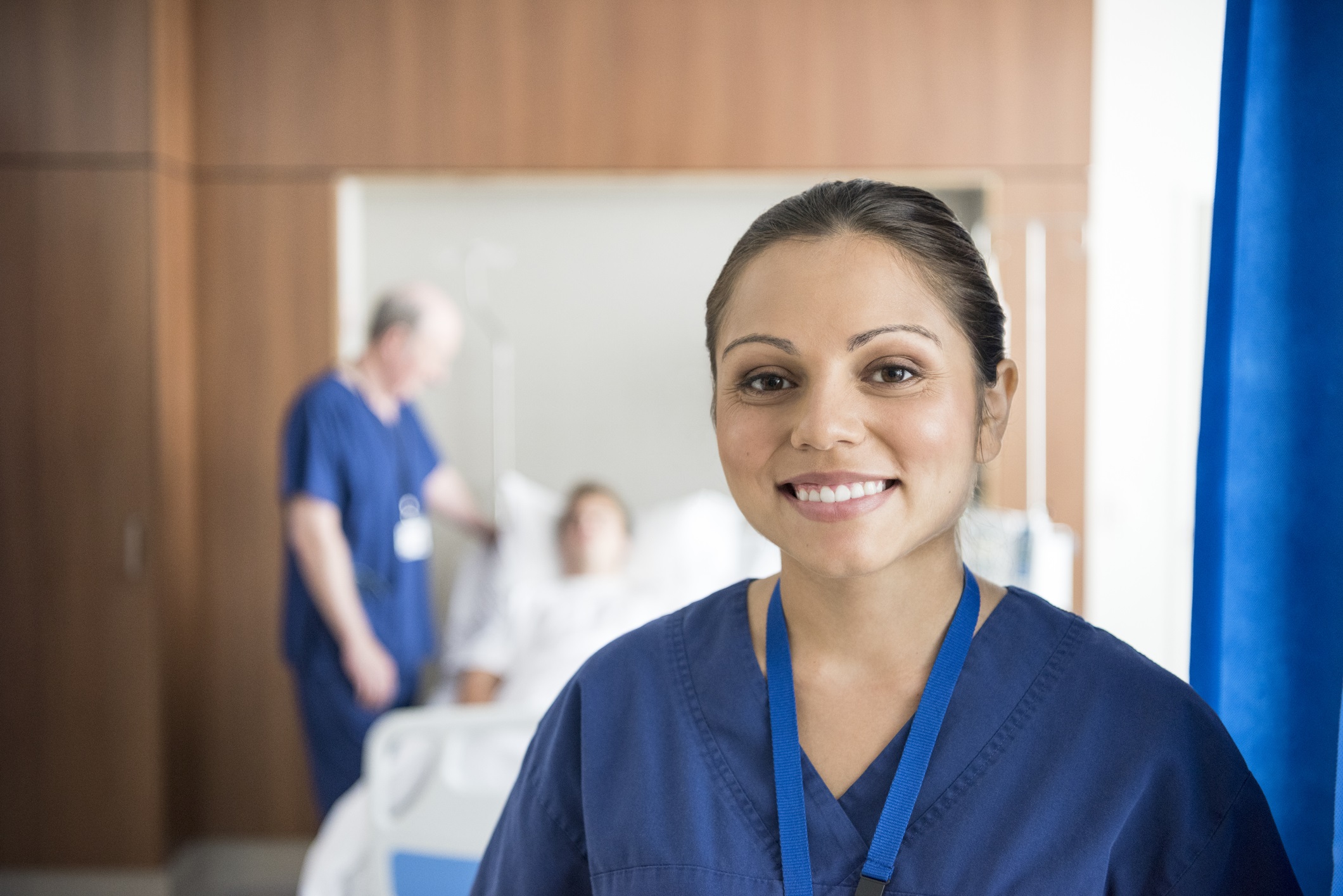 Female Aboriginal health care worker in blue uniform, smiling