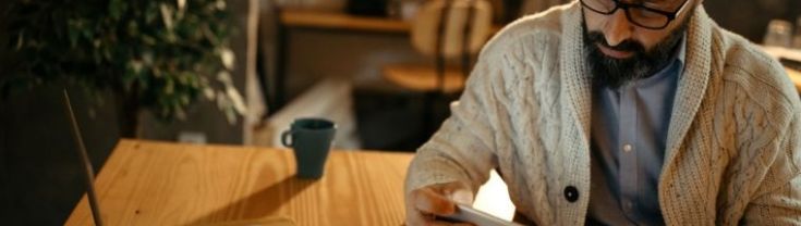 A male using a mobile phone to pay household bills