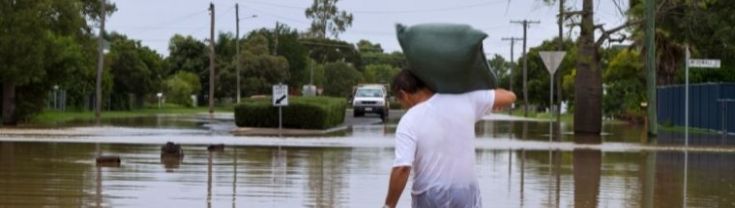 A man leaving his home walking through flood waters