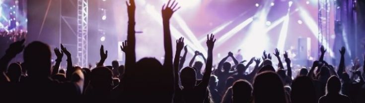 A crowd at a rock concert, with hands up in the air.