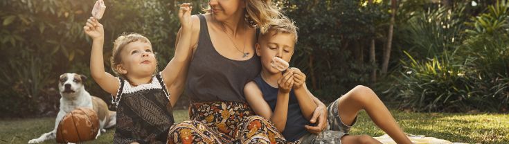 Single mother in the garden as the sun sets with son and daughter smiling