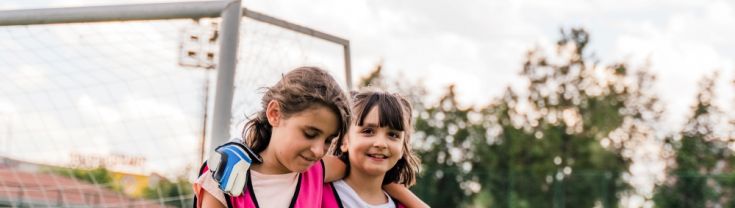 Two young girls playing soccer