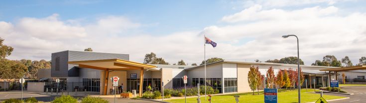 Main entry to the Junee Multipurpose Service. A sign indicating the main and emergency entry points is toward the right side of the image. The main entrance is toward the front of the image and the emergency entrance toward the back of the image. 