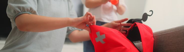 Lady and child packing a first aid kit