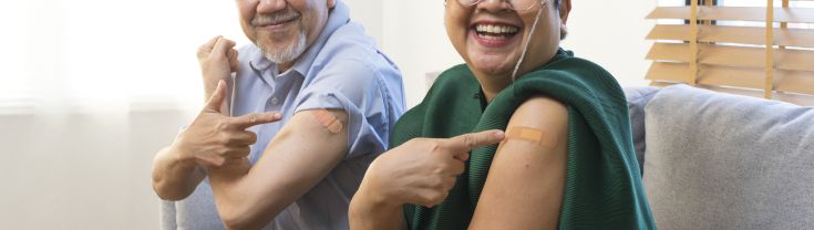 Seniors pointing to their arm after flu vaccine