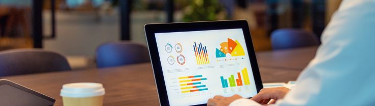 Close up of businessman using a laptop with graphs and charts on a laptop computer.