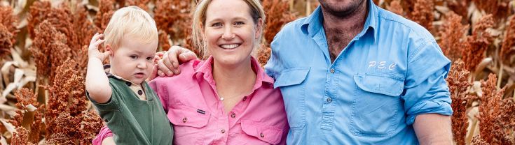 A family of farmers standing in front of a field of flowers