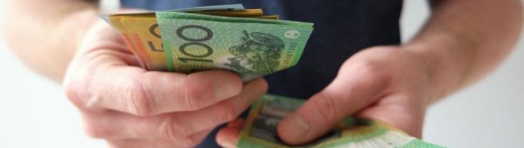 A man holding Australian money