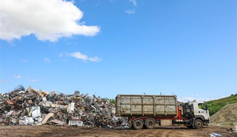 Truck unloading waste on land
