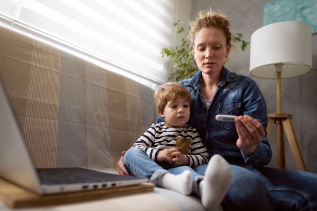 Mum with toddler checking thermometer