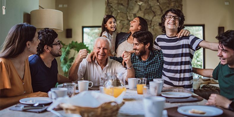 Family sitting around table laughing and smiling