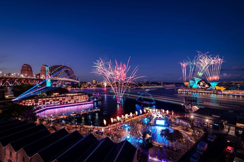 Fireworks going off over Sydney Harbour at dusk at Vivid Sydney.