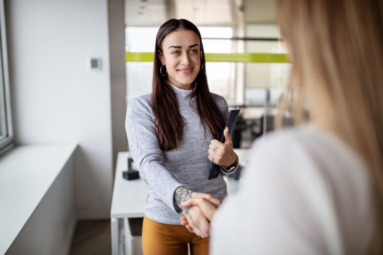 A woman shaking hands at a job interview